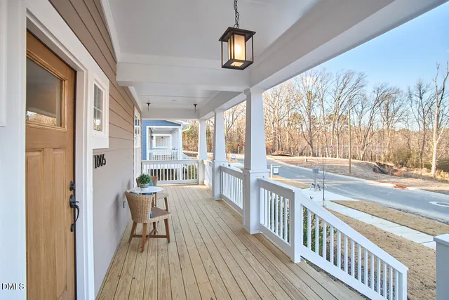 a kitchen with stainless steel appliances granite countertop a stove top oven a sink a dining table and chairs with white cabinets