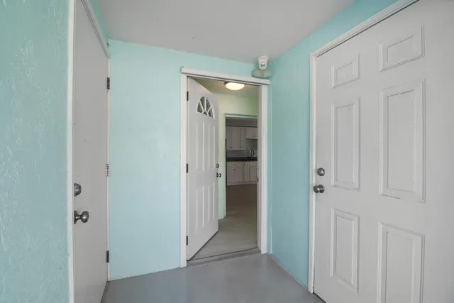 a view of a hallway with an entryway door