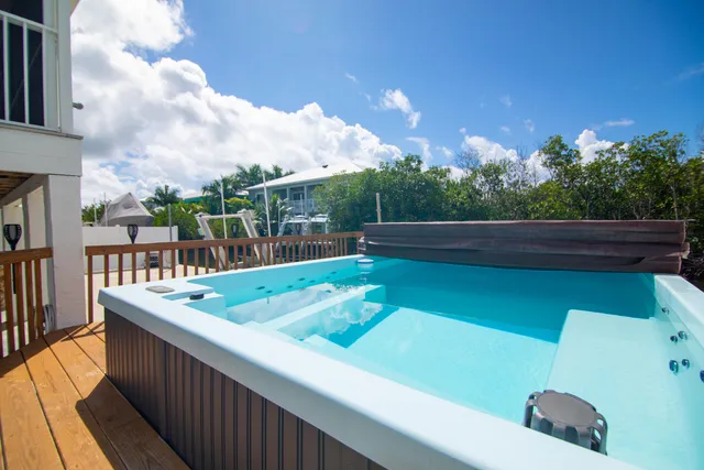 a view of a swimming pool with a patio and a yard