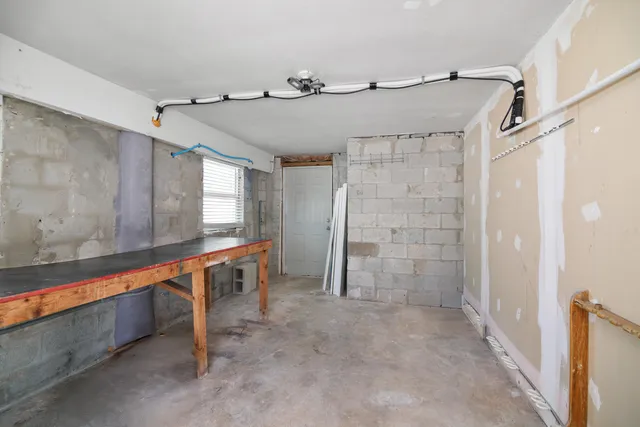 a bedroom with a bed next to a window with kitchen view