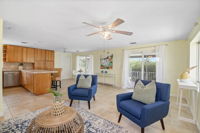 a living room with furniture kitchen view and a window