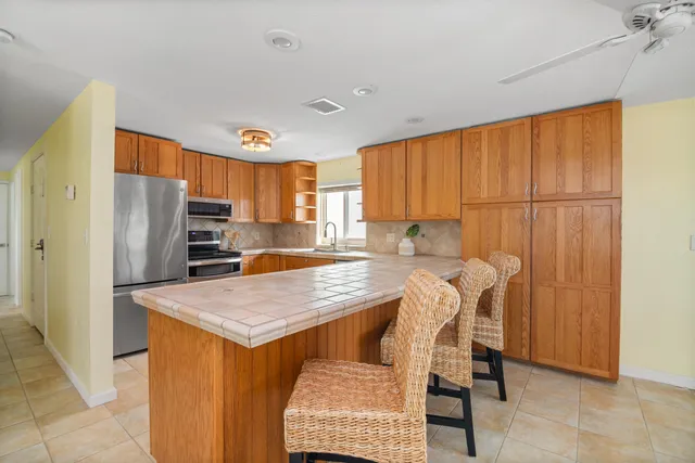 a kitchen with a refrigerator a table and chairs in it