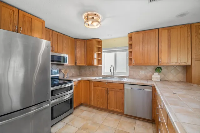 a kitchen with stainless steel appliances granite countertop a refrigerator sink and cabinets