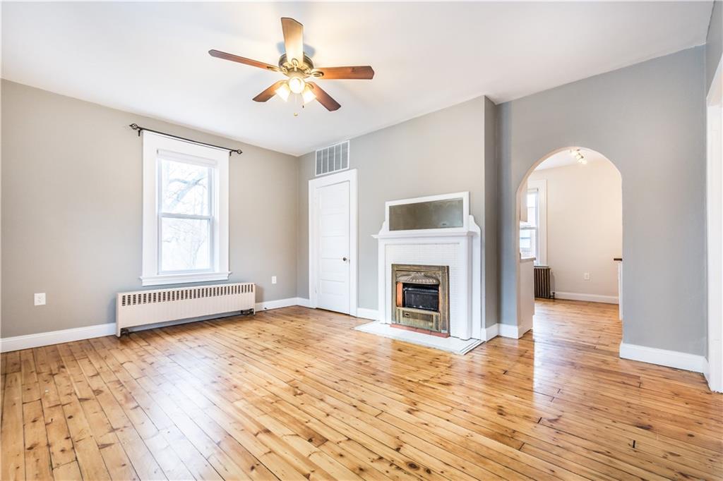 1549 McFarland Road Pittsburgh, PA 15216 - Photo 5 of 25 a view of empty room with wooden floor and fireplace