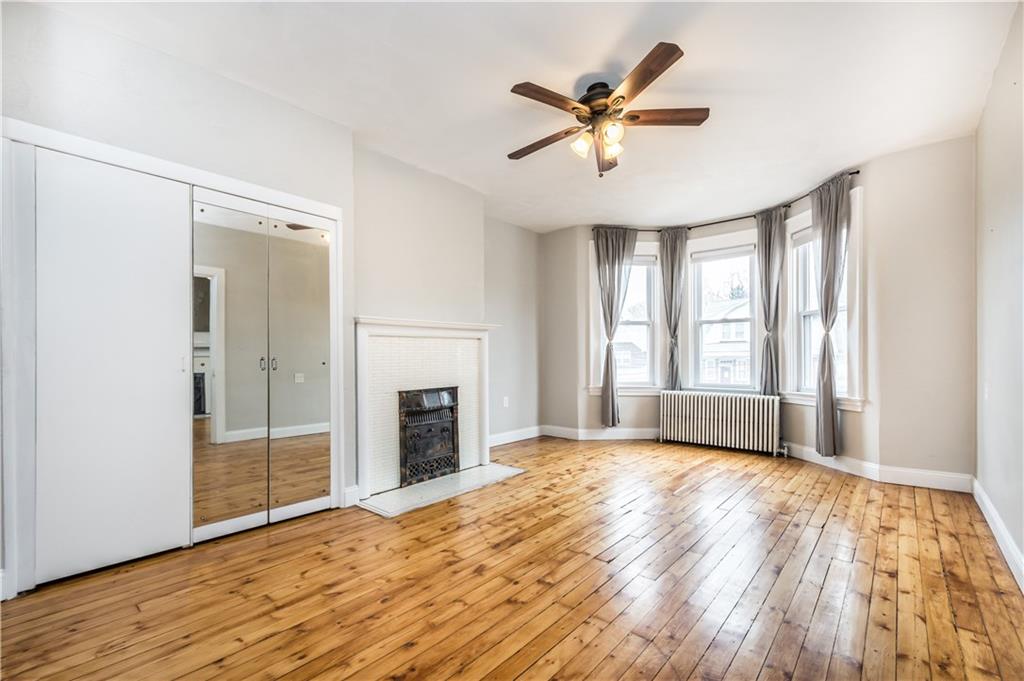 1549 McFarland Road Pittsburgh, PA 15216 - Photo 8 of 25 an empty room with wooden floor a ceiling fan and windows