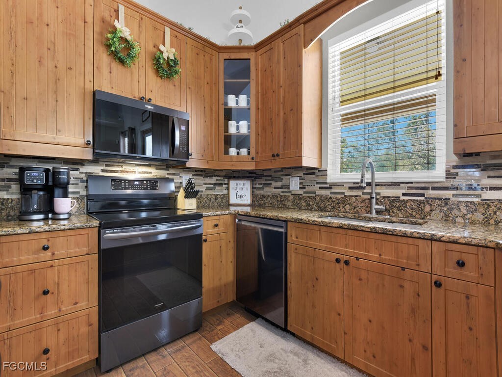 6041 Alan Boulevard Punta Gorda, FL 33982 - Photo 16 of 44 a kitchen with stainless steel appliances granite countertop a stove sink and microwave