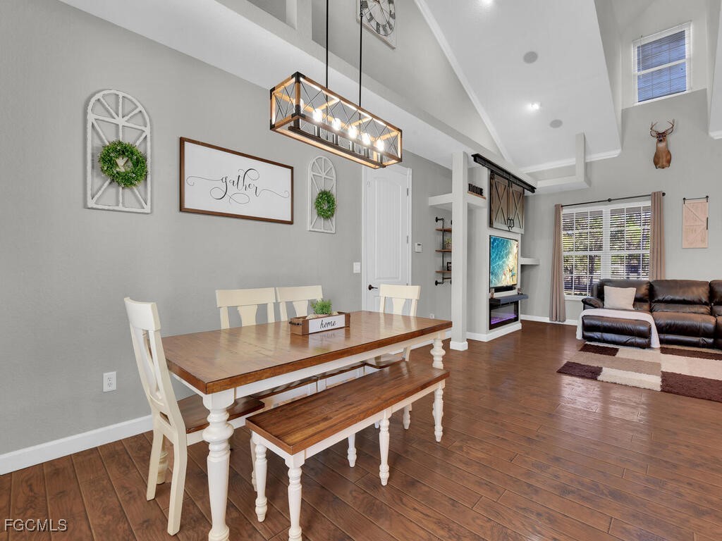6041 Alan Boulevard Punta Gorda, FL 33982 - Photo 20 of 44 a dining room with wooden floor a chandelier a wooden table and chairs
