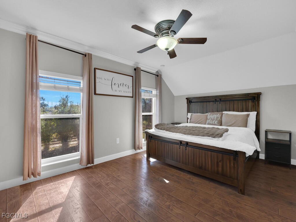 6041 Alan Boulevard Punta Gorda, FL 33982 - Photo 21 of 44 a spacious bedroom with a large bed and a chandelier