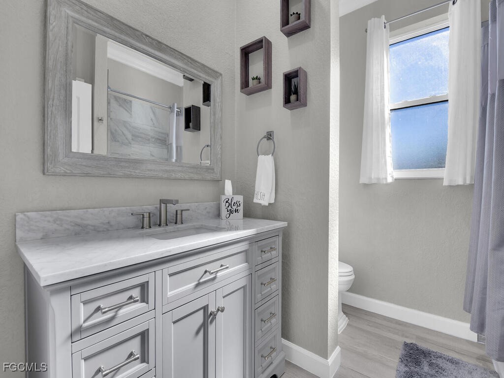6041 Alan Boulevard Punta Gorda, FL 33982 - Photo 29 of 44 a bathroom with a granite countertop sink and a mirror