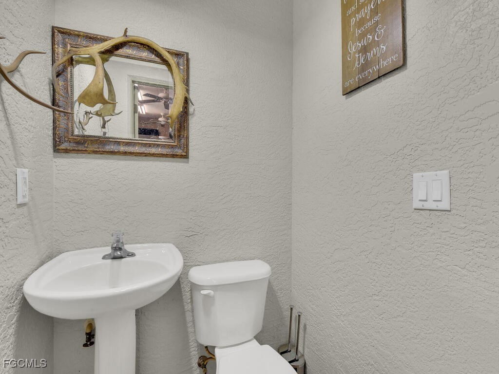 6041 Alan Boulevard Punta Gorda, FL 33982 - Photo 32 of 44 a bathroom with a toilet a sink and mirror
