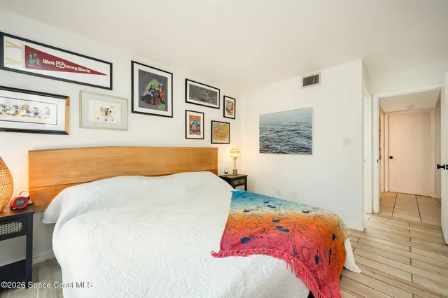 a bedroom with a bed and painting on the wall