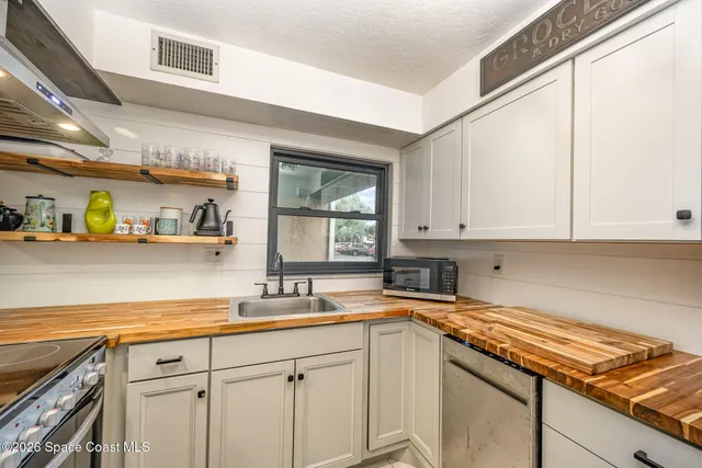 a kitchen with stainless steel appliances granite countertop a sink a stove and cabinets