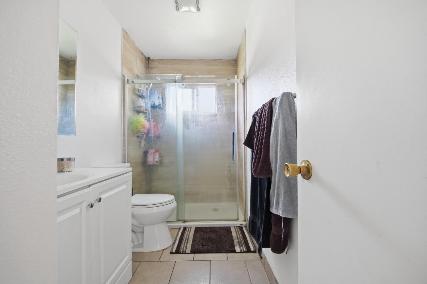 2250 Emerson Avenue Merced, CA 95341 - Photo 10 of 12 a bathroom with a sink a toilet a shower and a mirror