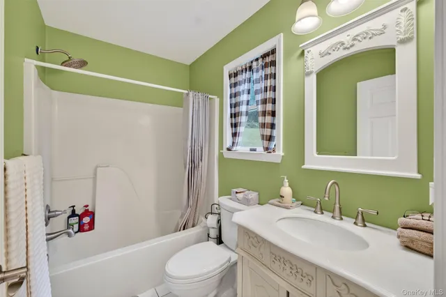 a bathroom with a granite countertop bathtub sink vanity mirror and toilet