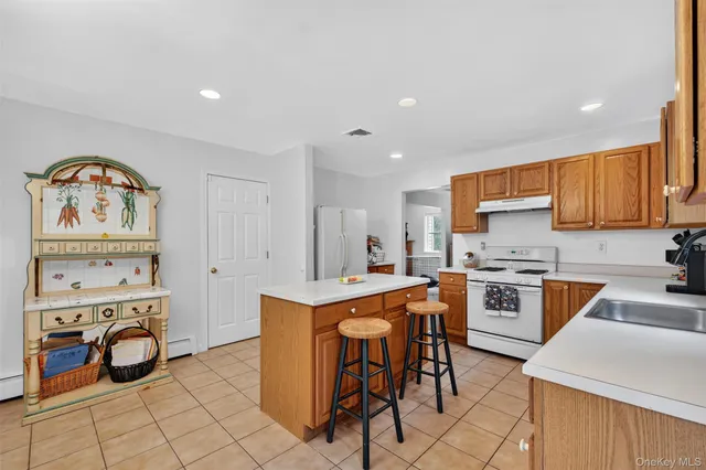 a view of a kitchen that has a table and chairs in it