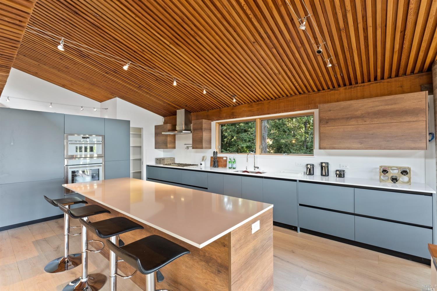 655 Edgewood Avenue Mill Valley, CA 94941 - Photo 29 of 85 a kitchen with stainless steel appliances kitchen island granite countertop a table chairs sink and cabinets