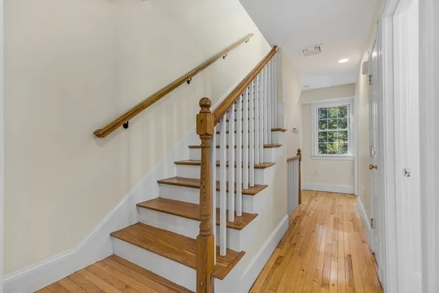 a view of a hallway with wooden floor and entryway