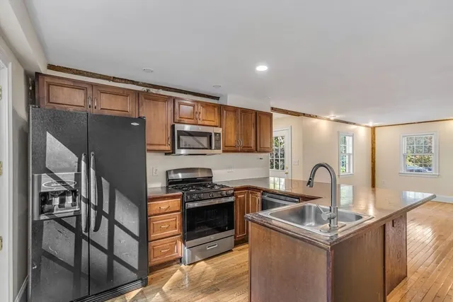 a kitchen with stainless steel appliances granite countertop a sink stove and cabinets