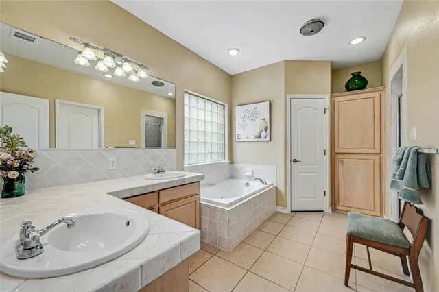 a bathroom with a tub sink and mirror
