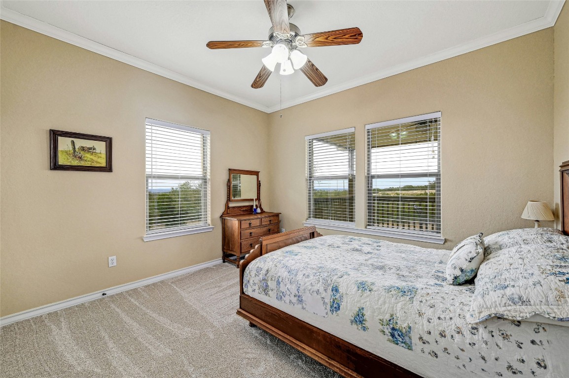 1370 Sunset View Fischer, TX 78623 - Photo 18 of 28 a bedroom with a bed a window and a chandelier