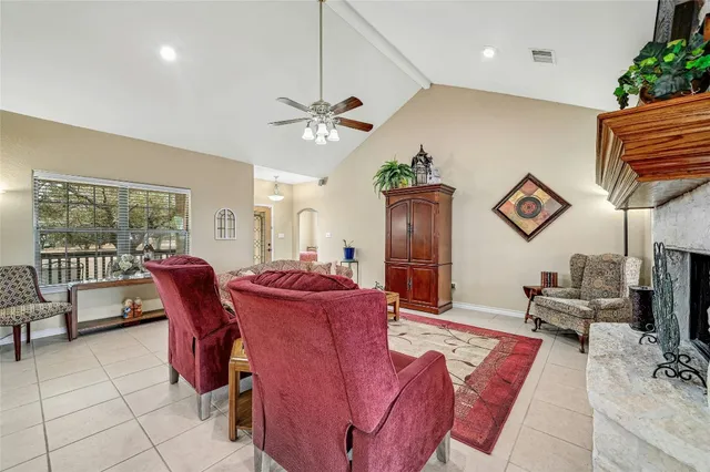 a living room with furniture a fireplace and a potted plant