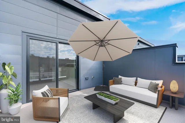 a balcony with furniture and umbrella