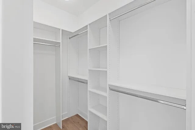 a view of walk in closet with empty racks