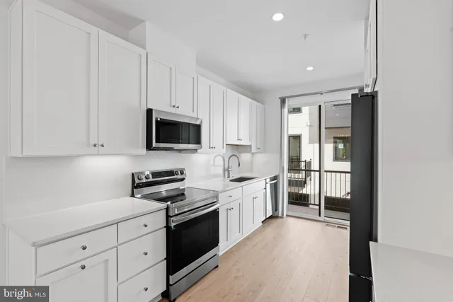 a kitchen with white cabinets and appliances
