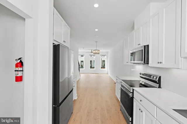 a kitchen with stainless steel appliances a refrigerator and a stove top oven