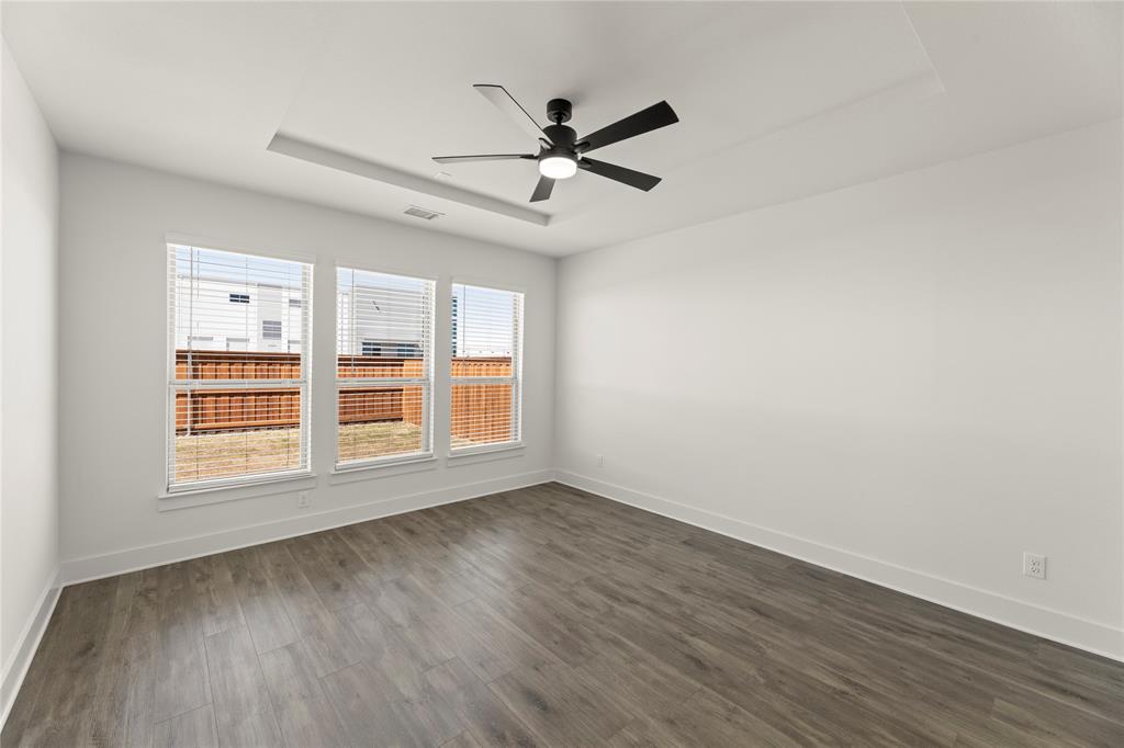 1314 Comal Drive Forney, TX 75126 - Photo 15 of 30 an empty room with wooden floor fan and windows