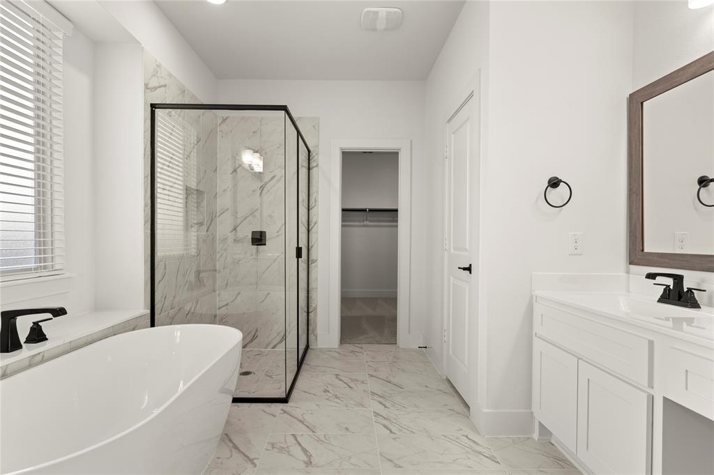 1314 Comal Drive Forney, TX 75126 - Photo 18 of 30 a bathroom with a tub a sink and a mirror