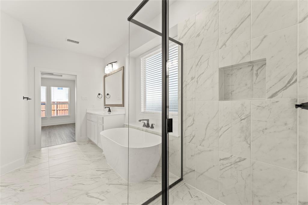 1314 Comal Drive Forney, TX 75126 - Photo 20 of 30 a spacious bathroom with a granite countertop sink a mirror and a bathtub