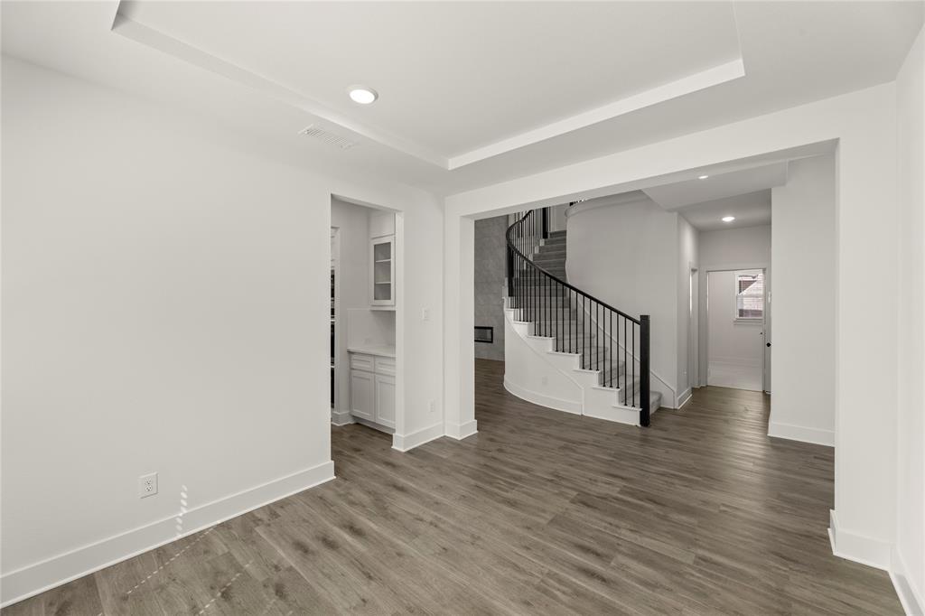 1314 Comal Drive Forney, TX 75126 - Photo 6 of 30 a view of an empty room with wooden floor and a hallway