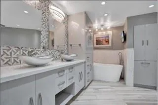 a bathroom with a double vanity sink mirror and bathtub