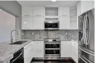 a kitchen with stainless steel appliances granite countertop a refrigerator and a stove top oven