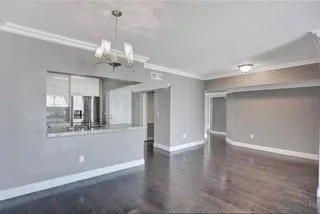 a view of a room with chandelier and wooden floor