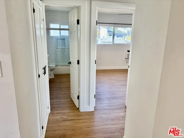 a view of a hallway with wooden floor and closet