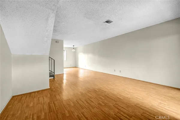 a view of a room with wooden floor and white walls