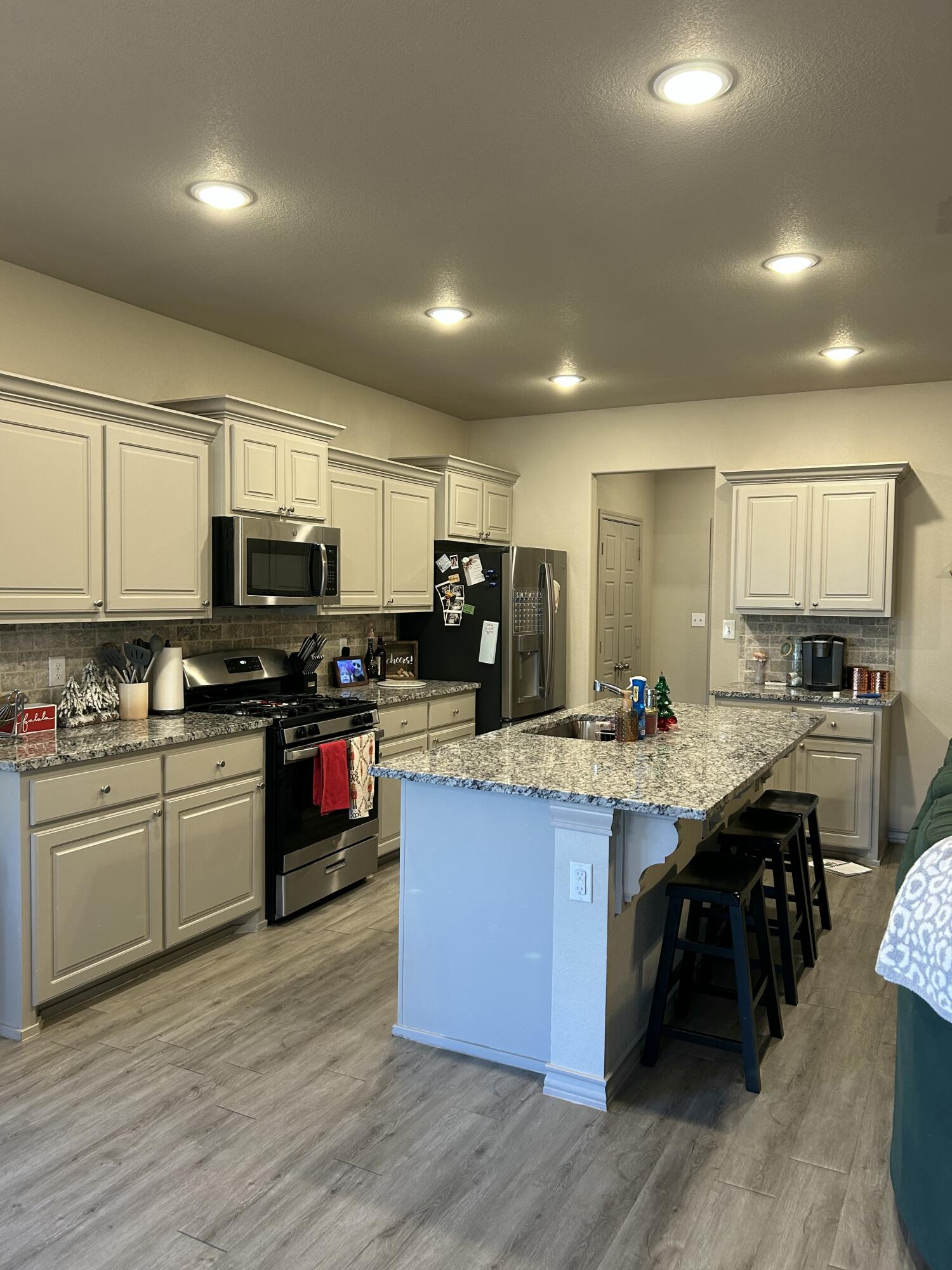 7020 22nd Street Lubbock, TX 79407 - Photo 12 of 28 a kitchen with stainless steel appliances granite countertop wooden cabinets a sink dishwasher a stove and a refrigerator