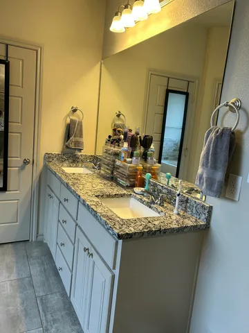 a bathroom with a granite countertop sink and a mirror