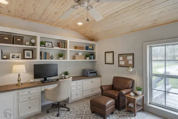 a view of a workspace with furniture and a window