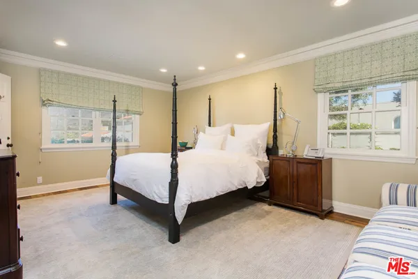 a bedroom with a large bed and a window