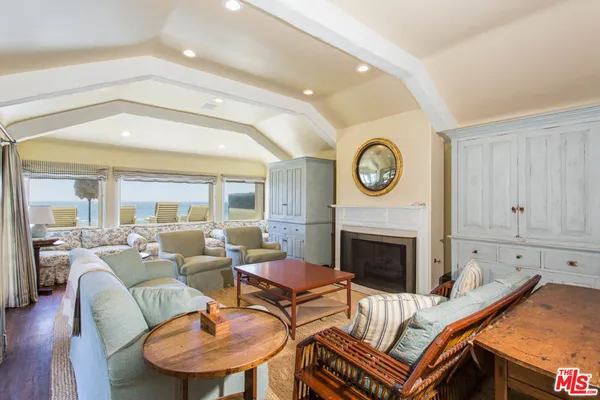 a living room with furniture a fireplace and a window