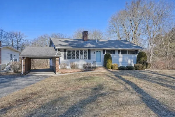 a front view of a house with a yard and sitting area