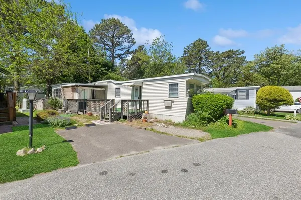a view of a house with backyard and a tree