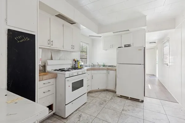 a kitchen with white cabinets and white appliances