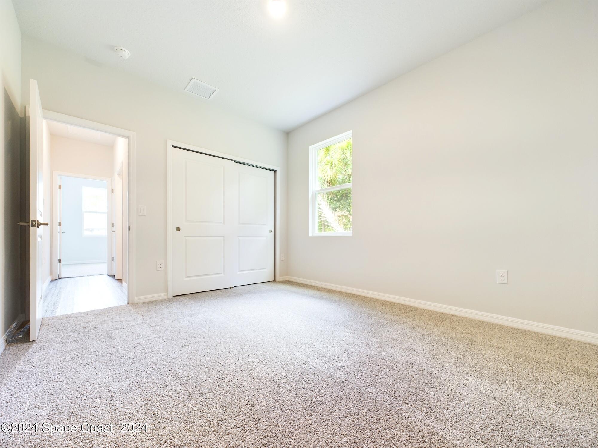 842 Angelico Road Northwest Palm Bay, FL 32907 - Photo 13 of 22 an empty room with windows and closet