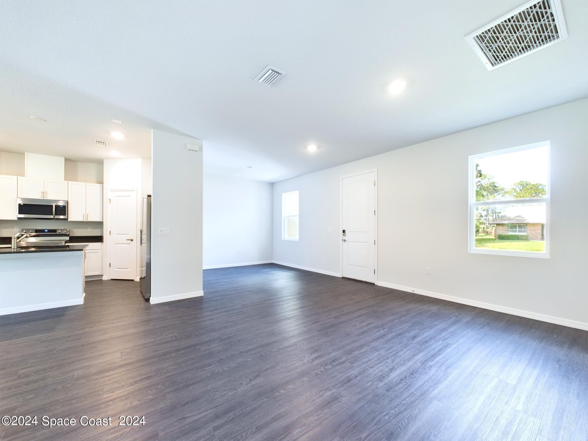 842 Angelico Road Northwest Palm Bay, FL 32907 - Photo 2 of 22 a view of kitchen with refrigerator and wooden floor