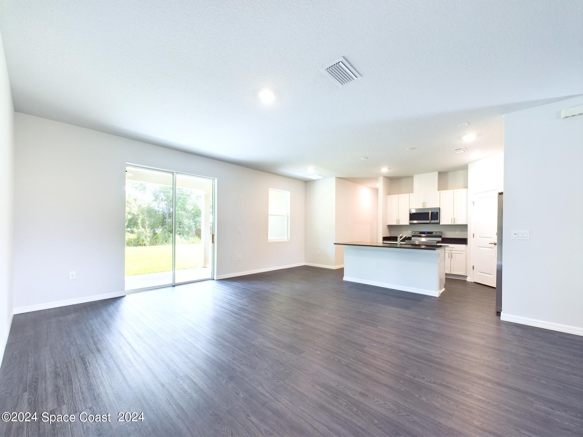 842 Angelico Road Northwest Palm Bay, FL 32907 - Photo 3 of 22 a view of kitchen with kitchen island wooden floor and stainless steel appliances