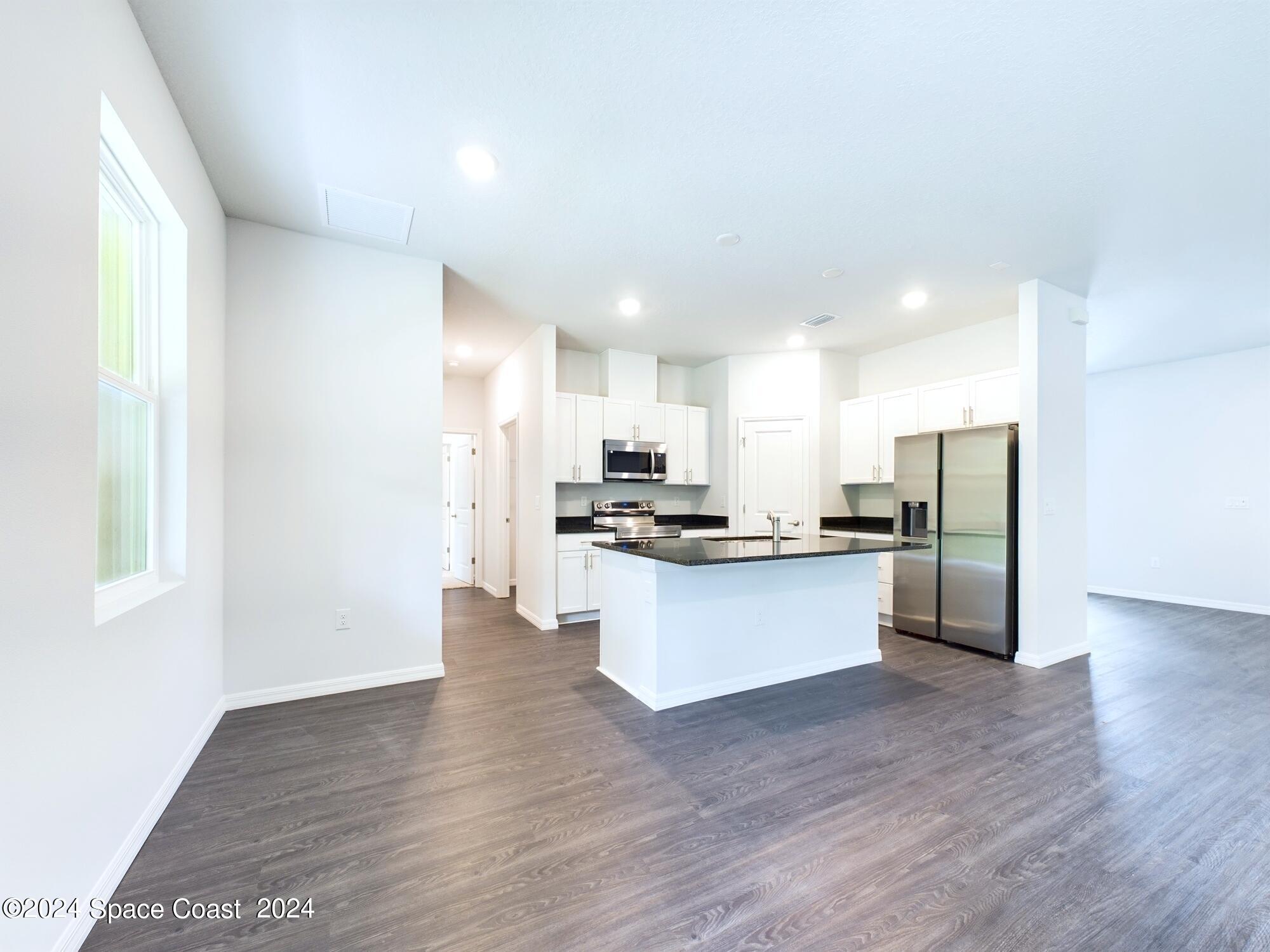 842 Angelico Road Northwest Palm Bay, FL 32907 - Photo 4 of 22 a large kitchen with a lot of counter top space and stainless steel appliances